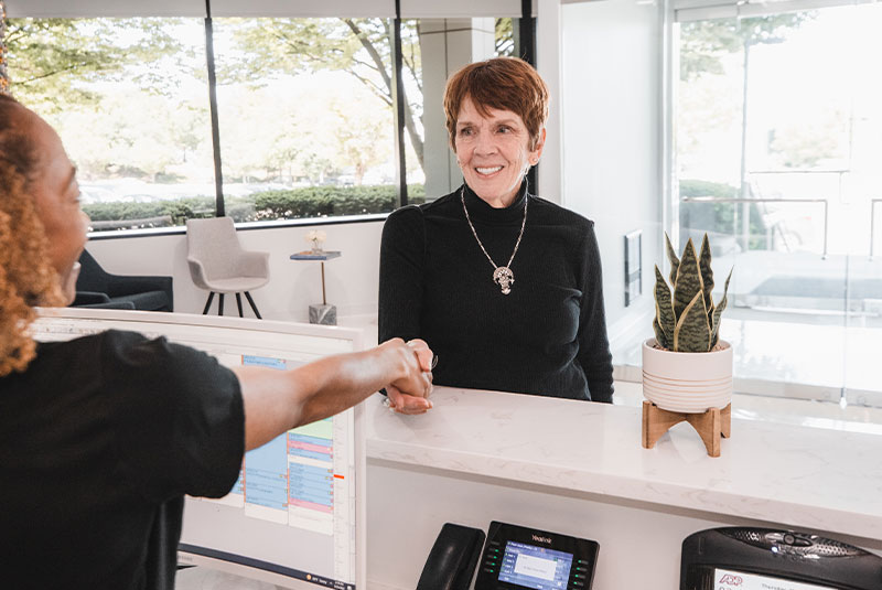 dental patient shaking hands with receptionist